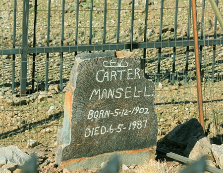 Gravestone for Mansel Carter (1902–1987) located within San Tan Mountain Regional Park, set among desert terrain and enclosed by a metal fence.