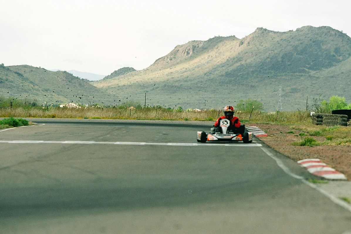 Adobe Dam - A rider in a red and black suit with a helmet on taking a sharp corner on the roadway.
